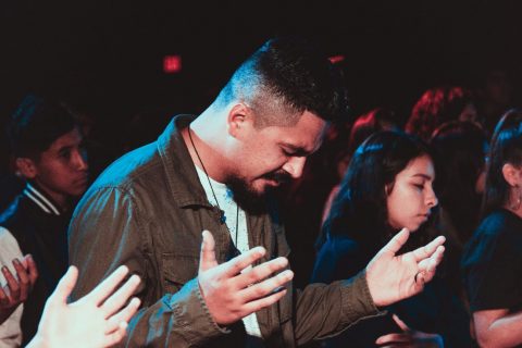 A man with other people sincerely praying